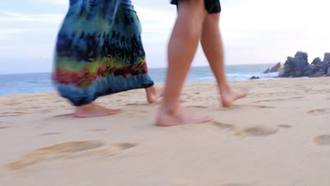 Close-up-of-the-feet-of-an-older-couple-walking-down-the-beach