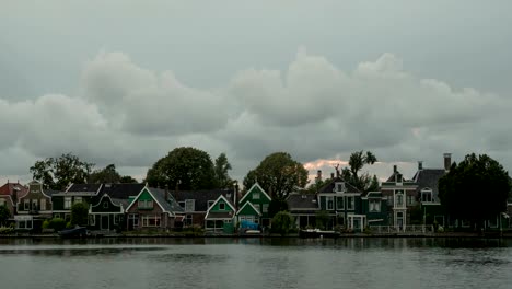 Timelapse-of-clouds-over-houses-on-river-bank,-Netherlands