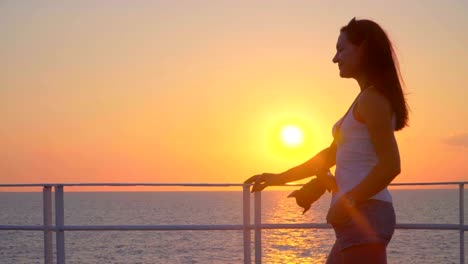 Silhouette-der-junge-attraktive-Frau-Sonnenuntergang-am-Kreuzfahrt-Schiff-im-Meer