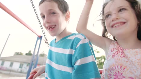 Niños-que-hace-pivotar-juntos-en-un-parque-infantil-público