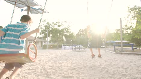 Niños-que-hace-pivotar-juntos-en-un-parque-infantil-público