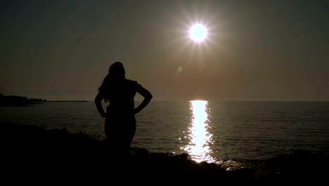 The-girl-is-developing-hair-on-the-beach-at-sunset.