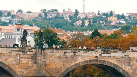 Puente-de-Carlos-de-Praga-sobre-el-río-Vltava,-en-el-cual-las-muchedumbres-de-turistas-pasear