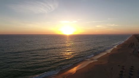 Fliegen-über-dem-Faro-Strand-(Praia-de-Faro)-bei-Sonnenuntergang,-Algarve,-Portugal