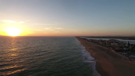 Flying-above-the-Faro-beach-(Praia-de-Faro)-during-sunset,-Algarve,-Portugal