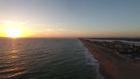 Fliegen-über-dem-Faro-Strand-(Praia-de-Faro)-bei-Sonnenuntergang,-Algarve,-Portugal