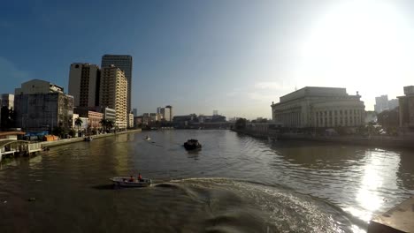 Motorized-boat-sailing-on-huge,-murky-Pasig-River-early-morning