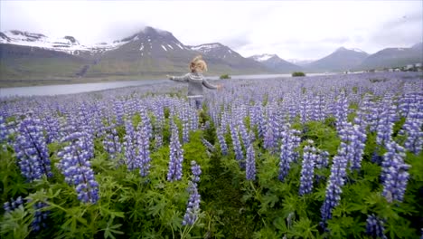 Joven-corriendo-en-campo-altramuz-de-flor-en-Islandia-viven-una-vida-feliz-y-disfrutando-de-vacaciones-en-el-norte-de-país-Slow-motion-video-gente-viaje-divertido-concepto