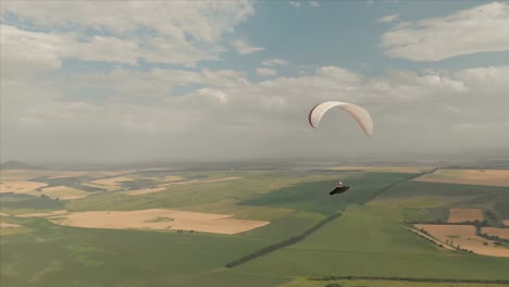 Athlet-Gleitschirm-fliegt-auf-seinem-Gleitschirm-neben-die-Schwalben.-Follow-up-Aufnahmen-aus-der-Drohne