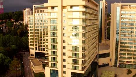 Modern-multi-storey-buildings-with-mirror-Windows-at-sunset,-aerial-shot