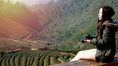 4K-Aufnahmen-von-glücklich-asiatische-Touristen-Frau-nehmen-Foto-von-der-schönen-Natur-von-Feld-Teeplantage-in-Asien-mit-Digitalkamera-bei-Sonnenaufgang.-Reisen-und-Urlaub-Konzept