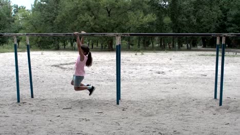 Girl-hanging-on-bars