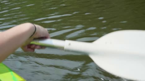 Young-girl-canoeing-on-a-beautiful-lake-with-close-up-on-paddle