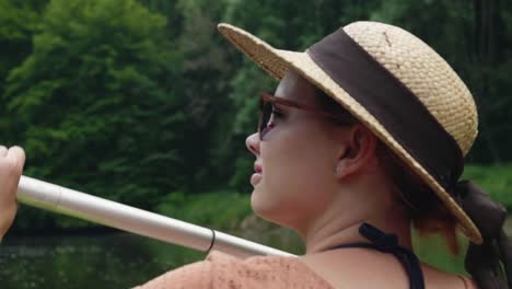 Chica-joven-canoa-en-un-lago-y-mirando-el-paisaje-en-agua-soleada