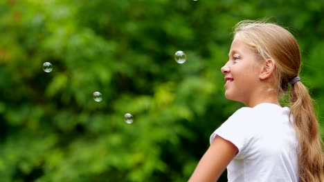 Little-girl-playing-with-soap-bubbles-outdoor.-Slow-motion.