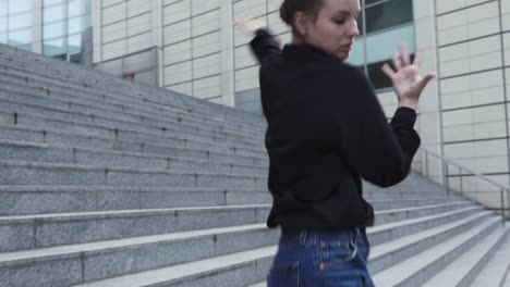 Young-Woman-Dancing-on-Office-Building-Steps