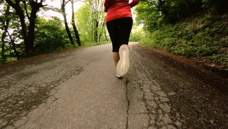 Niña-corriendo.-Chica-rubia-haciendo-deportes-al-aire-libre-en-el-bosque-de-verano.-Parte-trasera-vista-cámara-lenta-gran-angular.-Primer-plano-de-las-piernas-de-la-muchacha