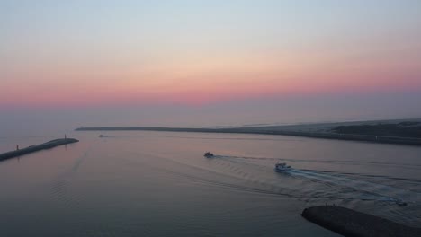 Boats-slowly-leaving-the-harbor-and-sailing-into-the-horizon-in-peaceful-ocean.