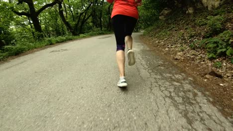 Niña-corriendo.-Chica-rubia-haciendo-deportes-al-aire-libre-en-el-bosque-de-verano.-Parte-trasera-vista-cámara-lenta-gran-angular.-Primer-plano-de-las-piernas-de-la-muchacha