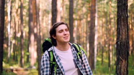 Cheerful-African-American-man-is-holding-map-and-asking-his-friends-to-follow-him-during-trip-in-forest-on-warm-summer-day.-Hiking,-nature-and-people-concept.