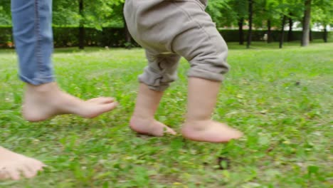 Mother-and-Baby-Walking-Barefoot-on-Grass