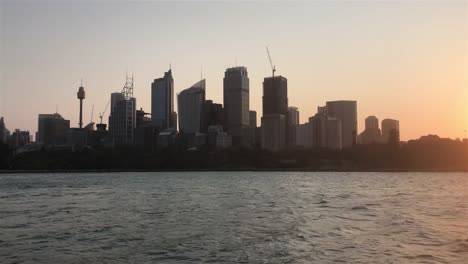 Establishing-shot-of-Sydney-city-skyline-at-harbour-during-sunset.