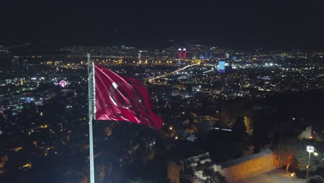 city-​​skyline-drawn-by-night-drone,--city-​​skyline-flag-in-front-of-kadifekale,-izmir