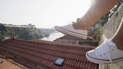 Woman-relaxing-on-high-top-wall-above-city