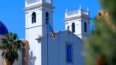 Flagge-von-Valencia-in-der-Nähe-der-Kirche-mit-einer-schönen-blauen-Kuppel-und-weißen-Glockentürmen