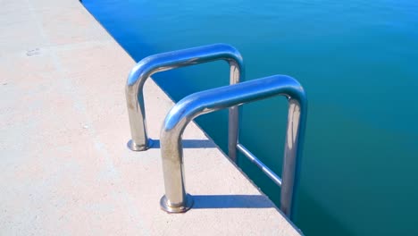 Shiny-chrome-metal-stair-on-the-pier-down-to-the-water