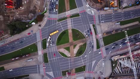 Aerial-city-view,-flying-over-a-city,-a-suggestive-perpendicular-aerial-video-above-a-traffic-roundabout-with-a-lot-of-traffic