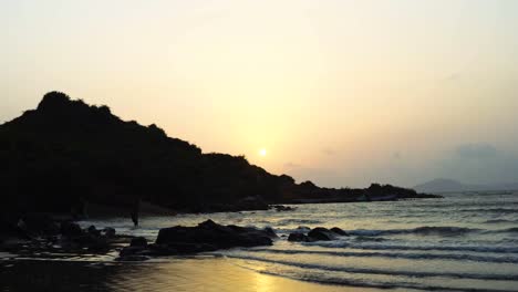 Waves-at-sea-shore-near-hill-in-sunset/-late-evening.