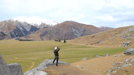 photographer-on-rock-cliff-of-castle-hill-arthur-pass-destination-new-zealand