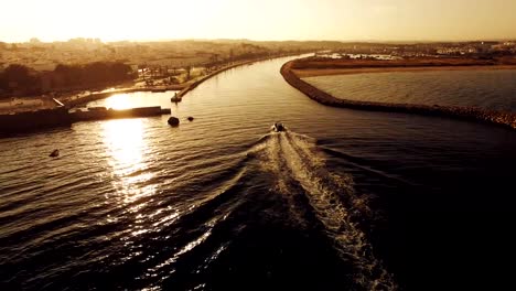 Barco-entra-en-el-puerto-al-atardecer-vista-aérea