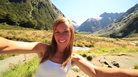 Young-woman-takes-selfie-portrait-in-beautiful-New-Zealand's-landscape