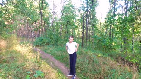 Slim-teen-boy-fulfills-long-steps.--Boy-is-trained-good-running.-Sports-in-nature.-Morning-sun-forest-at-dawn.