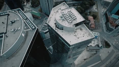 Aerial-drone-shot-of-a-city-downtown-with-glass-skyscrapers-and-traffic.