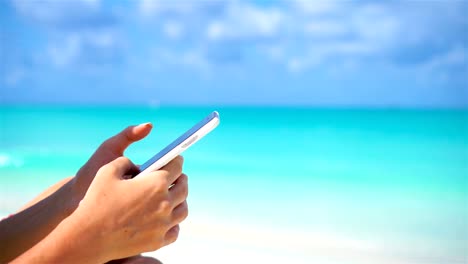 Junge-Frau-Nutzung-Telefon-während-der-tropischen-Strandurlaub.-Closeup-mobile-Smartphone.