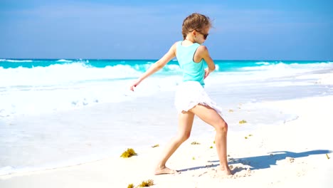 Adorable-little-girl-at-beach-having-a-lot-of-fun.-Sporty-active-kid-dancing-on-seahore