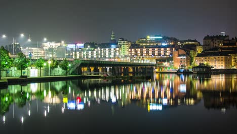 Stadtbrücke-und-Gebäude-im-Zentrum-von-Stockholm-in-der-Nacht-4K-Zeitraffer.-Stadtbild,-Spiegelungen-im-Wasser