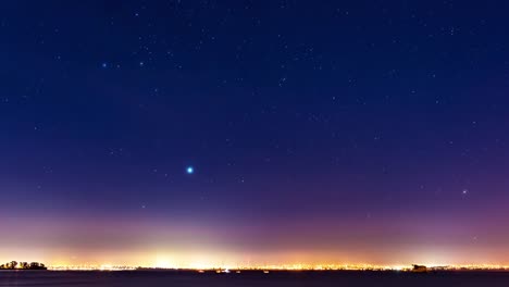 Nebel-und-einen-Sternenhimmel-in-Bewegung-über-die-Lichter-der-Skyline-einer-Stadt