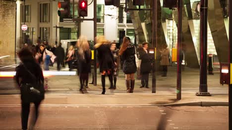 Pedestrians-crossing-a-road-at-night,-London,-England