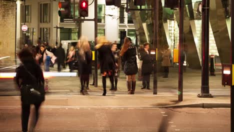 Peatones-cruzando-una-carretera-de-noche,-Londres,-Inglaterra