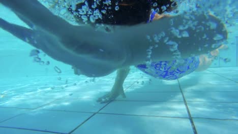 Underwater-footage-of-kids-jumping-and-diving-in-a-swimming-pool