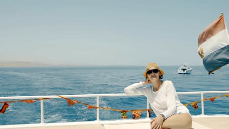 Woman-enjoying-a-trip-on-yacht-sitting-on-deck,-Egypt