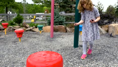 Kind-spielt-mit-Kieselsteinen-in-einen-Spielplatz-im-freien