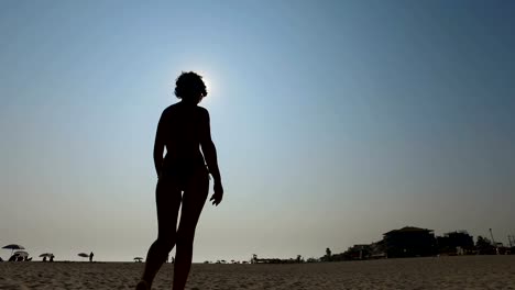 Silhouette-der-schönen-Frau-Fotomodell-mit-fitten-Körper-Spaziergang-am-Strand