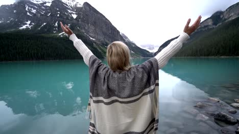 Young-woman-arms-outstretched-at-Lake-Louise