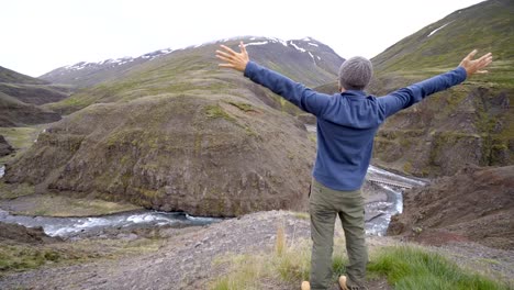 Young-man-on-top-of-canyon-arms-outstretched-for-happiness