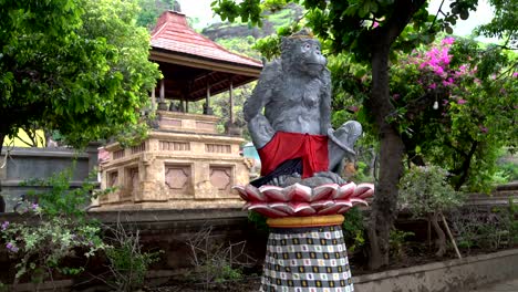 Die-Statue-ein-Affe-sitzt-auf-einer-Lotusblüte.-Springen-Sie-im-Hintergrund-Affen